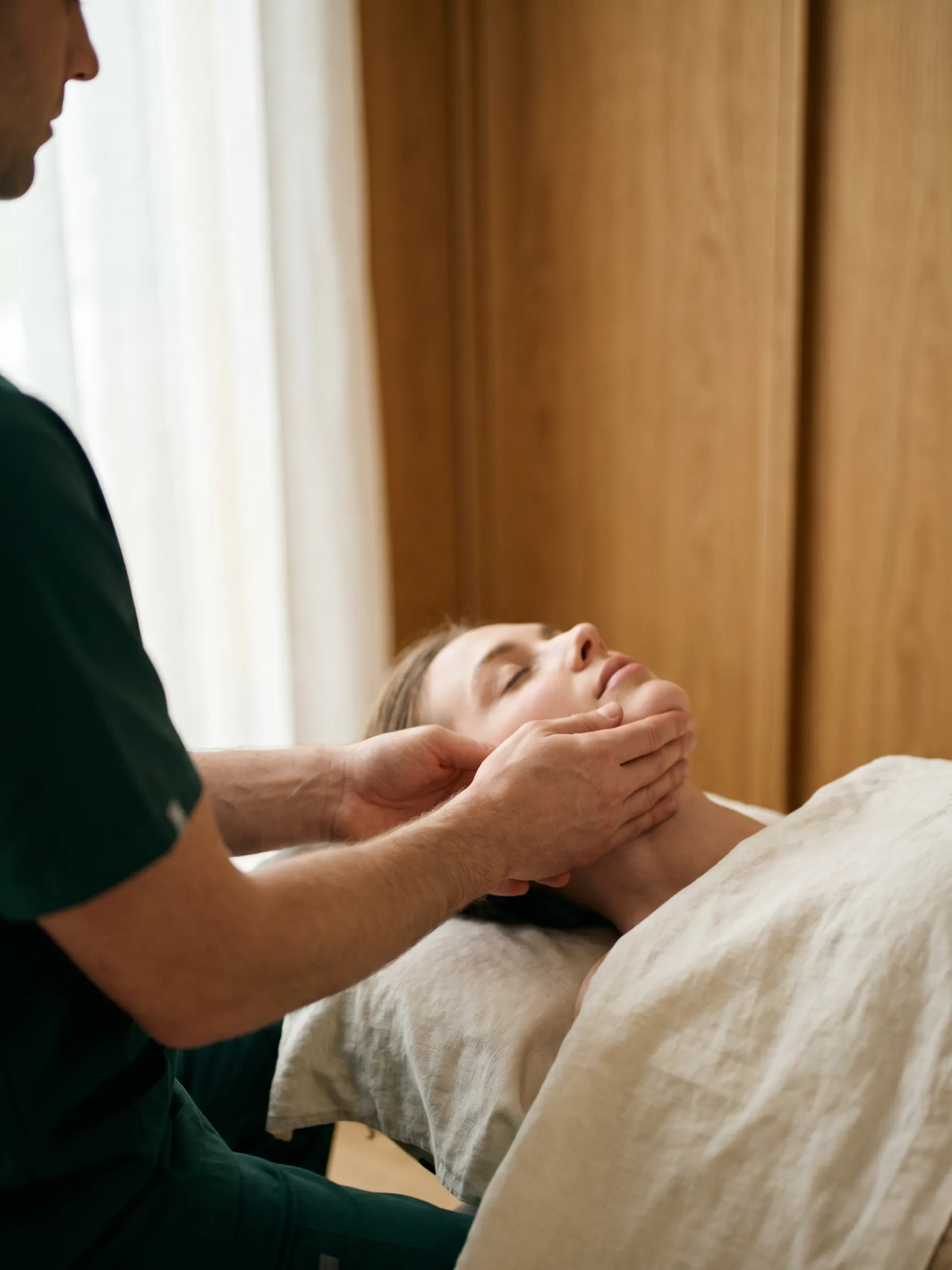 Specialist clinician assessing a patient's jaw and temporomandibular joint
